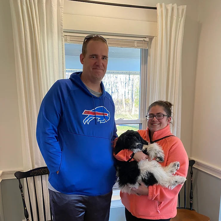 Husband and wife picking up their black and white Goldendoodle puppy from NY Dandy Doodles.